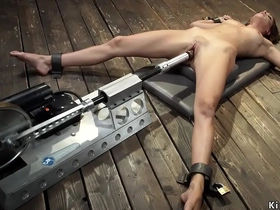 A brunette gets penetrated by a large brown dildo machine for an intense orgasm